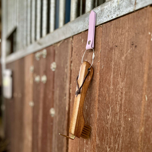 Magnet-Stallhelfer mit Hufkratzer auf Holz an einer Boxentür